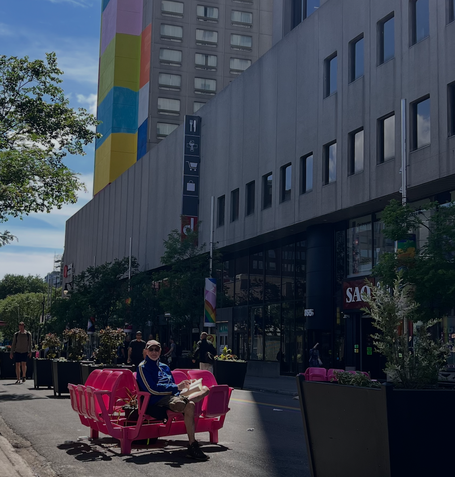 La piéto du Village | banc trouple rose sur la rue Sainte-Catherine avec murale colorée en arrière-plan
