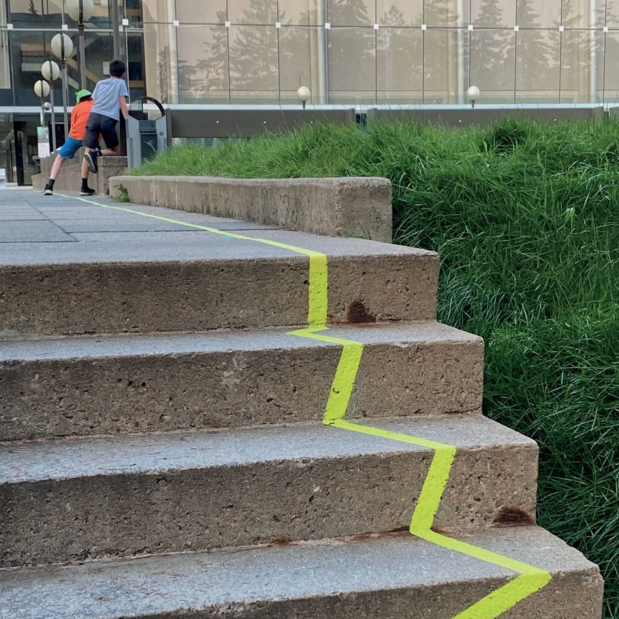 Enfants grimpant les escaliers du MNBAQ avec le tracé jaune en zigzag